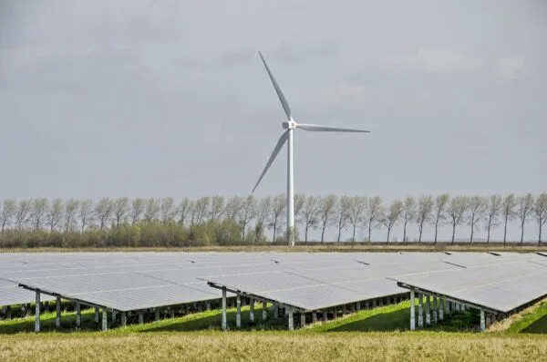 Landschap met een windmolen en zonnepanelen.